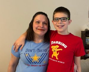 Christinne and her son wearing t-shirts from her company